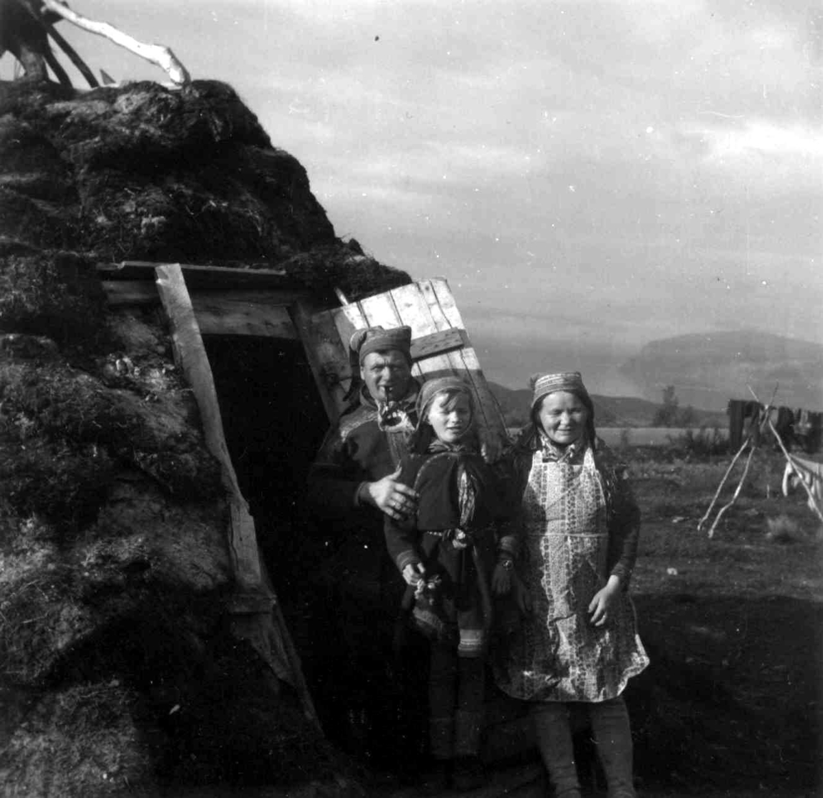 Portrett av Mathis Johansen Eira med familie foran en gamme, august 1958.