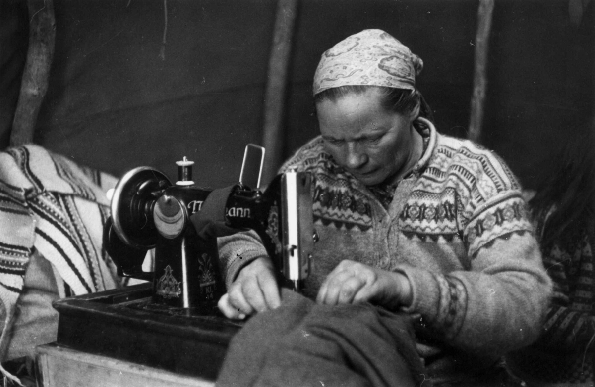 Maskinsøm. Ellen Marie Anti syr på symaskin i telt. Isfjordfjellet 1959.