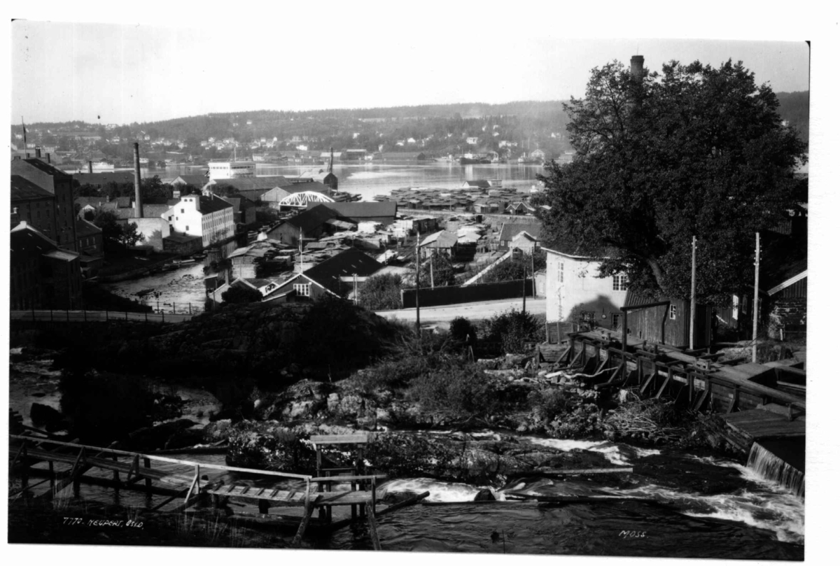 Moss. 1930. Oversiktsbilde. Bybebyggelse. Fabrikkområde. I bakgrunnen vann og villaområde.