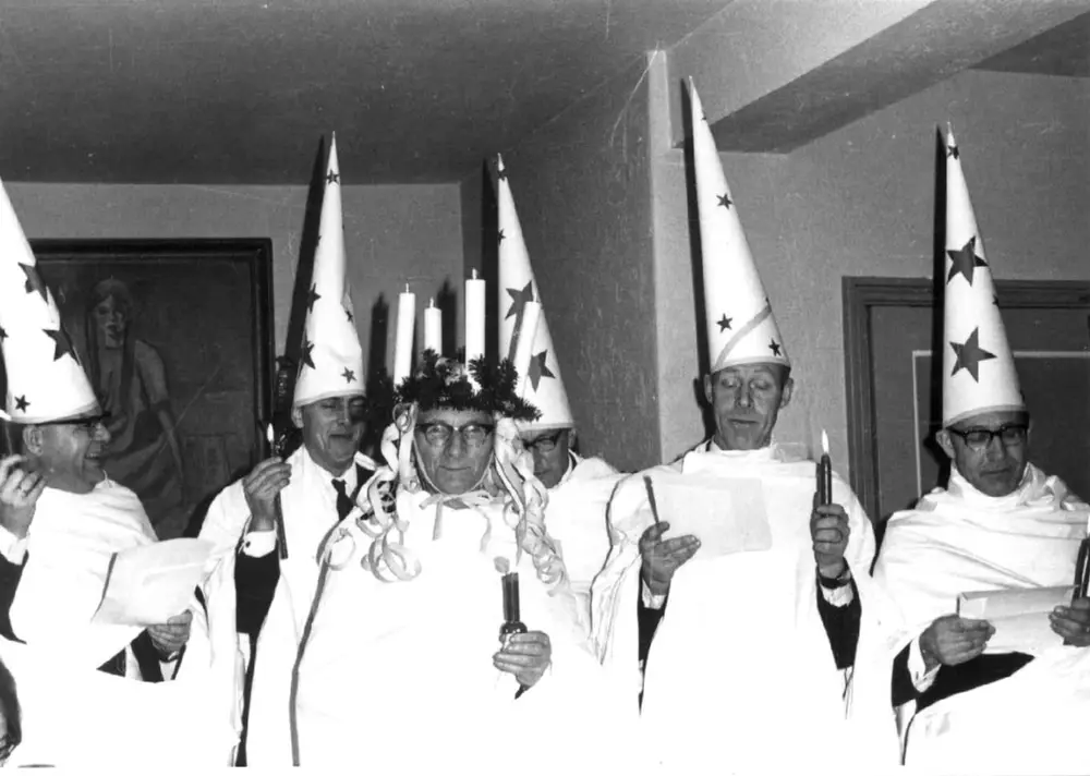 Professor Hilmar Stigum, førstekonservator ved Norsk Folkemuseum, som St. Lucia, omgitt av stjernegutter, på en fest for etnologi- og folkeminnestudenter i Studentbyen på Sogn, i Oslo i 1965.