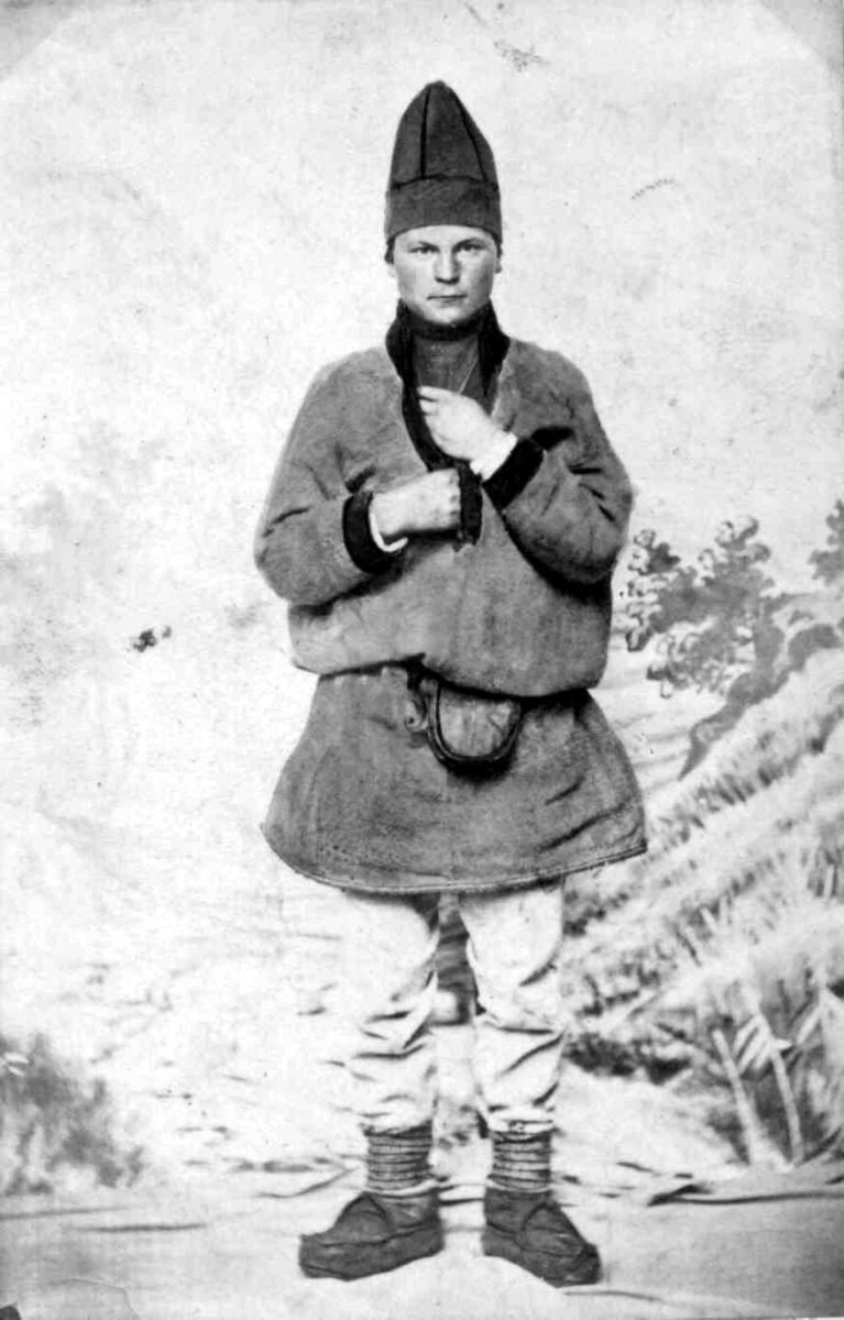 53. Mannsdrakt, samedrakt, Salten. Portrett av mann stående i fotoatelier foran malt naturbakgrunn. 
Fra serien "Norske Nationaldragter" (nr.53) tatt av fotografen Marcus Selmer (1819-1900), Bergen.