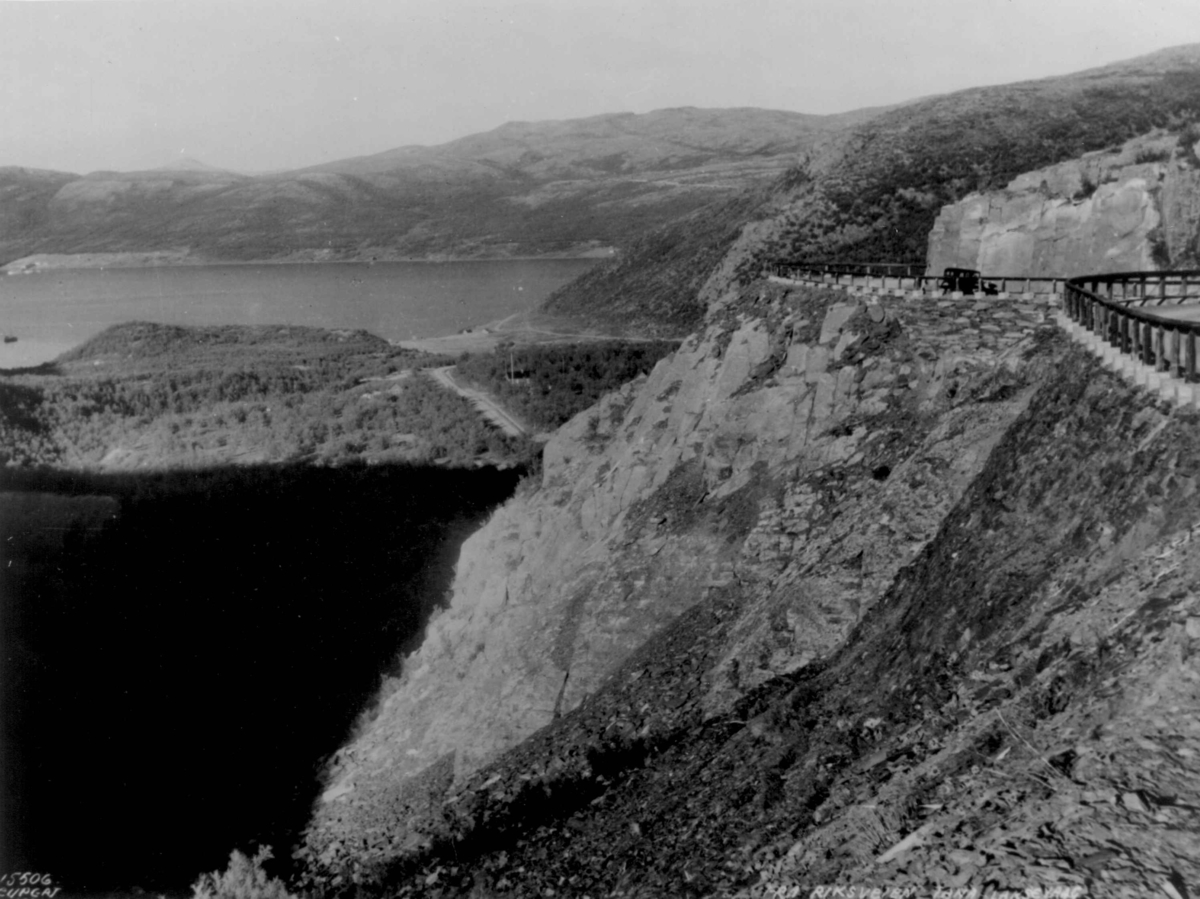 En bil kjører på veien fra Vestertana til Ifjord i Laksefjorden. Bak skimtes fjordarmen Vestertana med Vestertana skoleinternat til venstre.