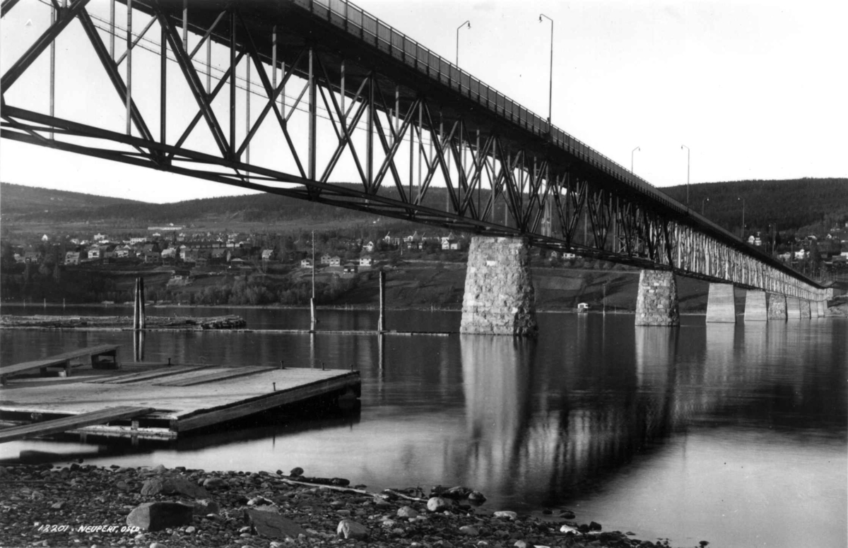 Bru over Mjøsa, Lillehammer 1935. Landskap med bebyggelse, skog og åser i bakgrunnen.