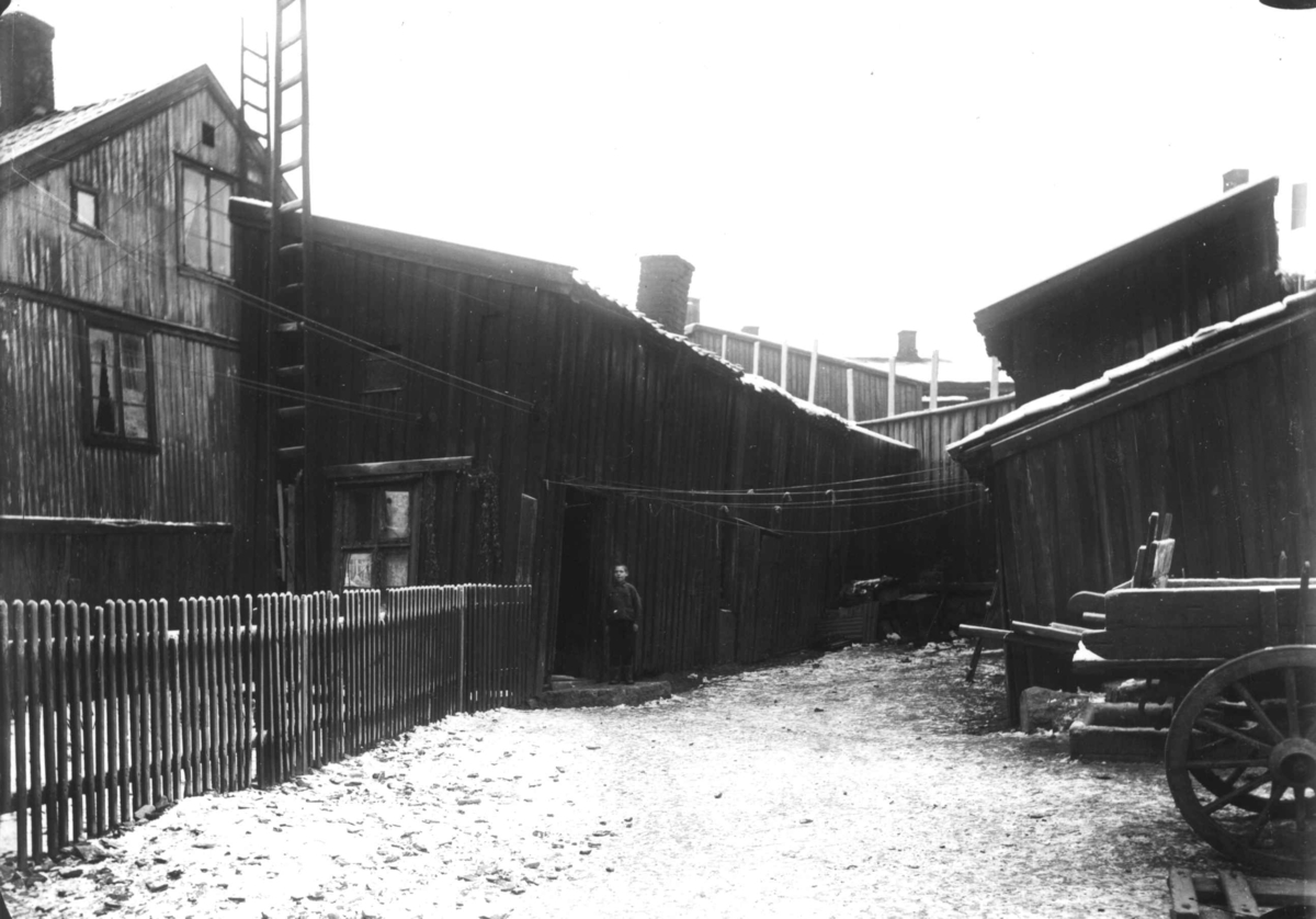 Gårdsrom med bolighus og vognskur (?), vogner plassert på gårdsplassen. Muligens Rodeløkka, Oslo.
Fra boliginspektør Nanna Brochs boligundersøkelser i Oslo 1920-årene.