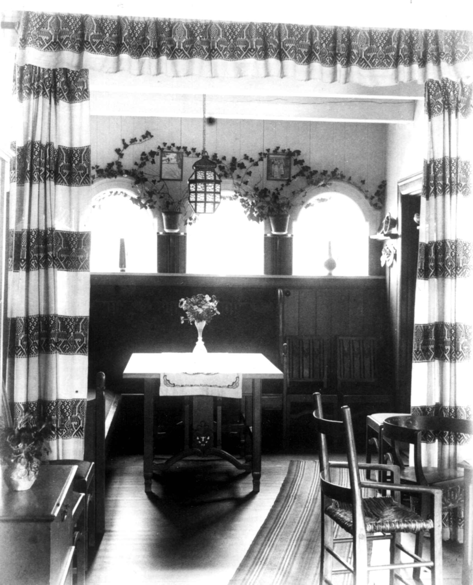 Interiør fra Karistua på Lysaker i Akershus. Tegnet av Arnstein Arneberg og bygd 1910 til Karen Grude Koht og Halvdan Koht. Interiør med portierer og møbler.