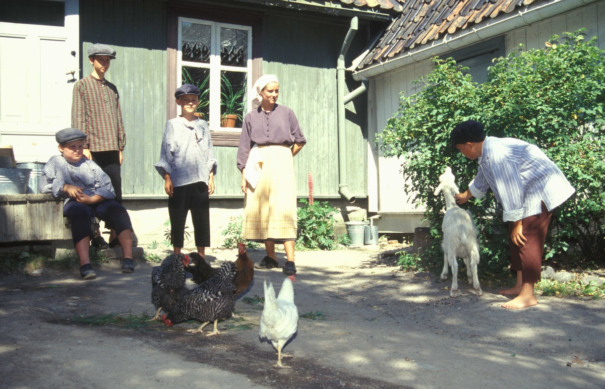 Levendegjøring på museum.
Ferieskole august 2002.
Fra gårdsplassen til Johannesgate 12 bygning nr. 203, og 14 bygning nr. 204 på Enerhaugen, hvor noen av barna og noen høns koser seg i sola.
Norsk Folkemuseum, Bygdøy.