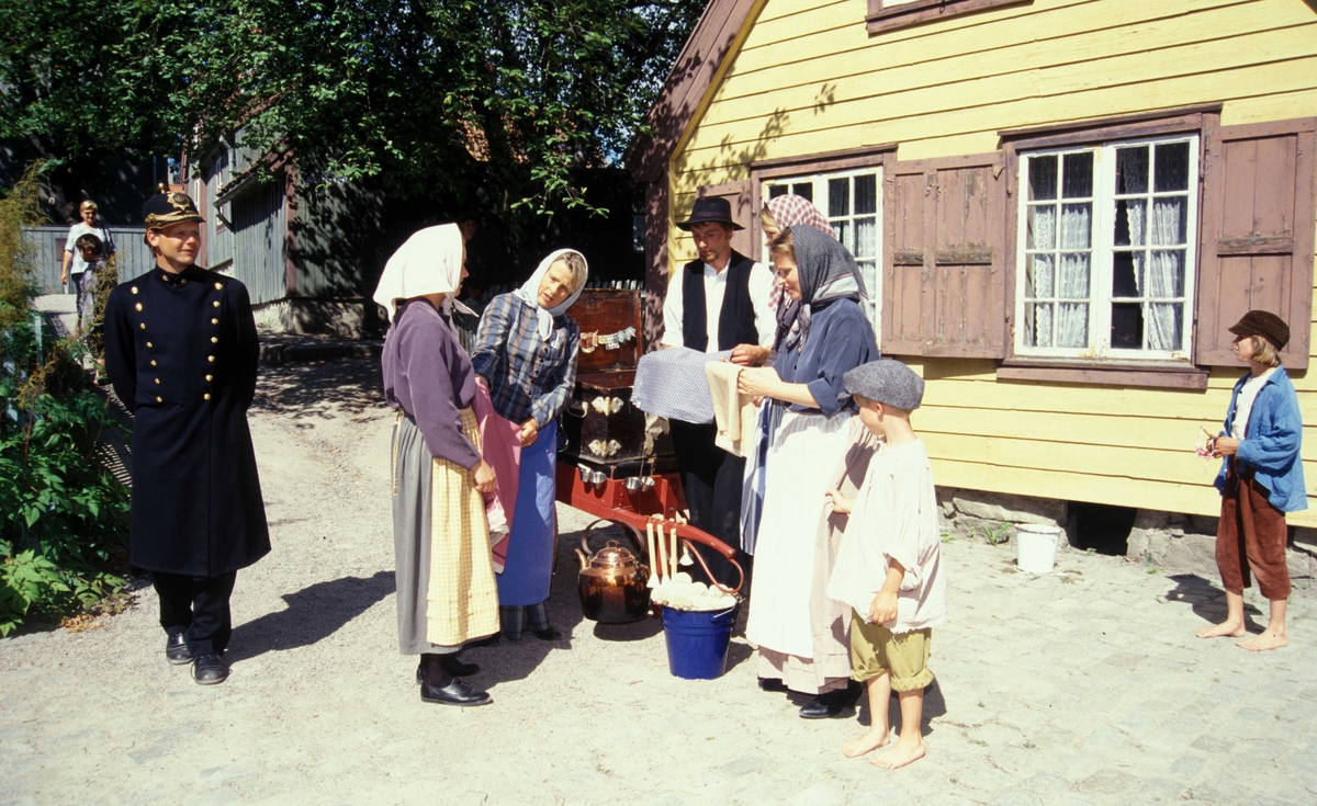 Tilstelning på Norsk Folkemuseum ved forstadshus fra Kanten 1B, Hammersborg ca. 1800.
Kramkaren er på besøk, og politiet passer på.