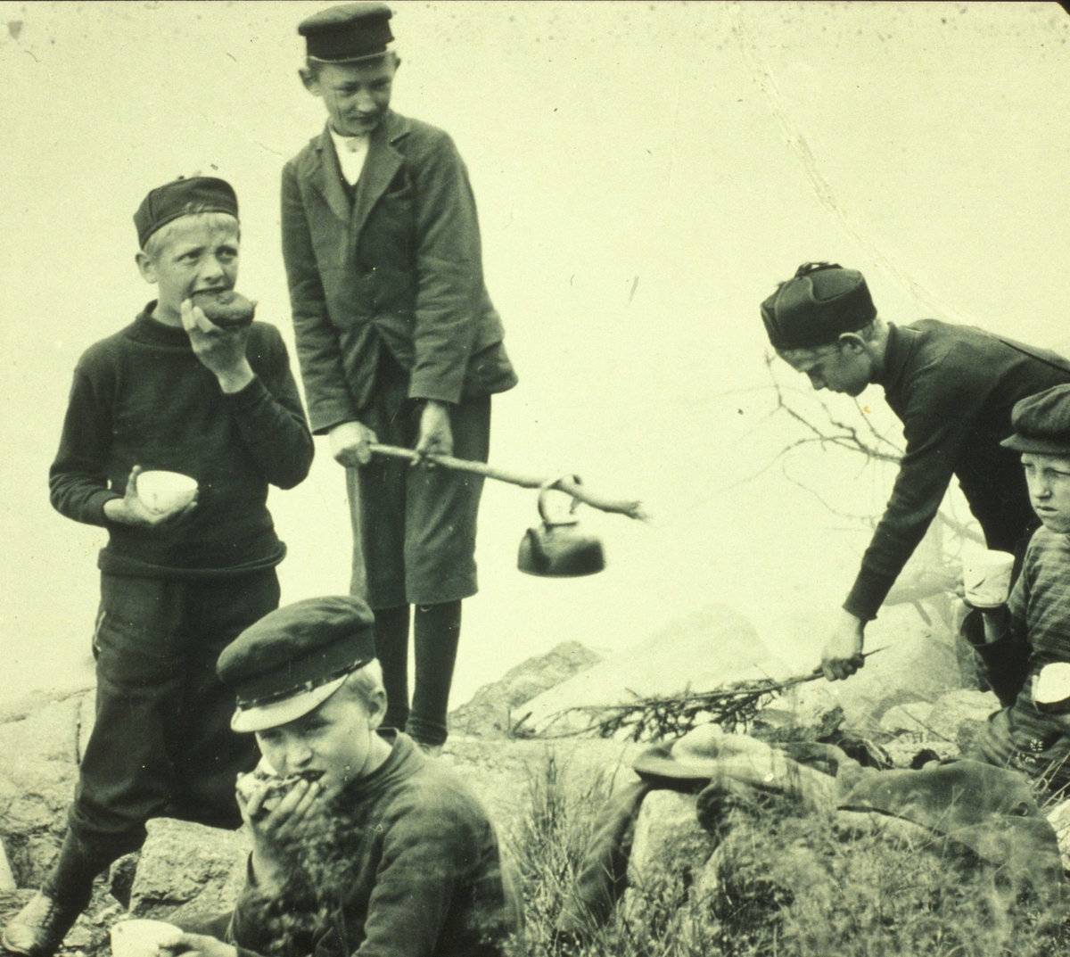 Gutter på tur ca. 1905.
Smågutter koker kaffe ? på bål og spiser mat i friluft ved strandkanten.