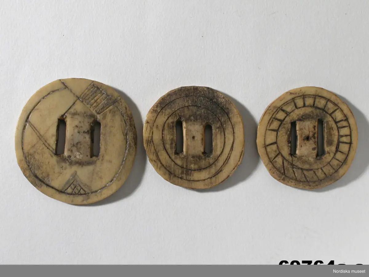 Huvudliggaren:
"a-c Knappar fr. Enontekis kapellförs., Finska lappmarken. Af renhorn. a.   b.   c.   Ink. fr. Johan Speinsen Tornaeus, Kautokaeinolapp. Ink. af jägmästaren Hugo Samzelius. 1891. Bil. Samzelius 466."