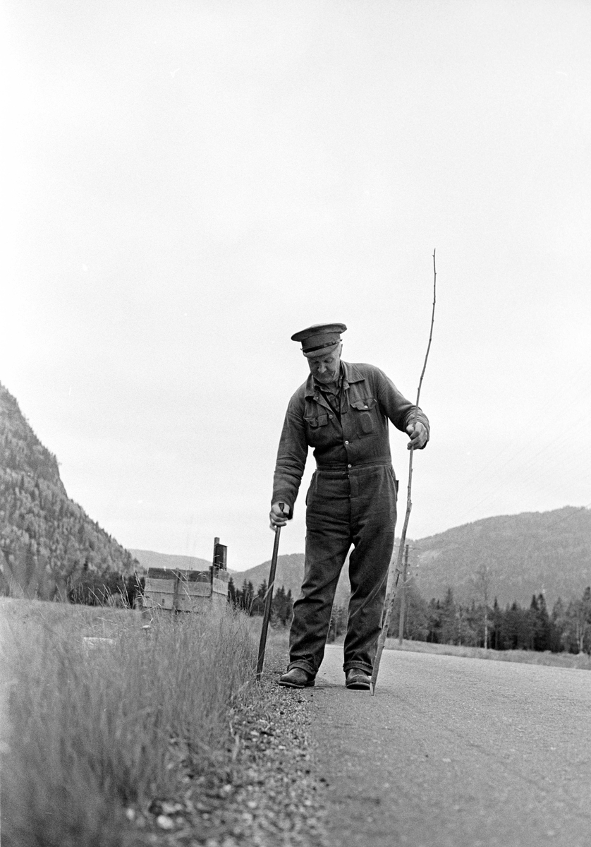 Antakelig veiarbeider Jon Tveit som setter ned brøytepinner for vinteren, Setesdal, Aust-Agder. Fotografert oktober 1966.