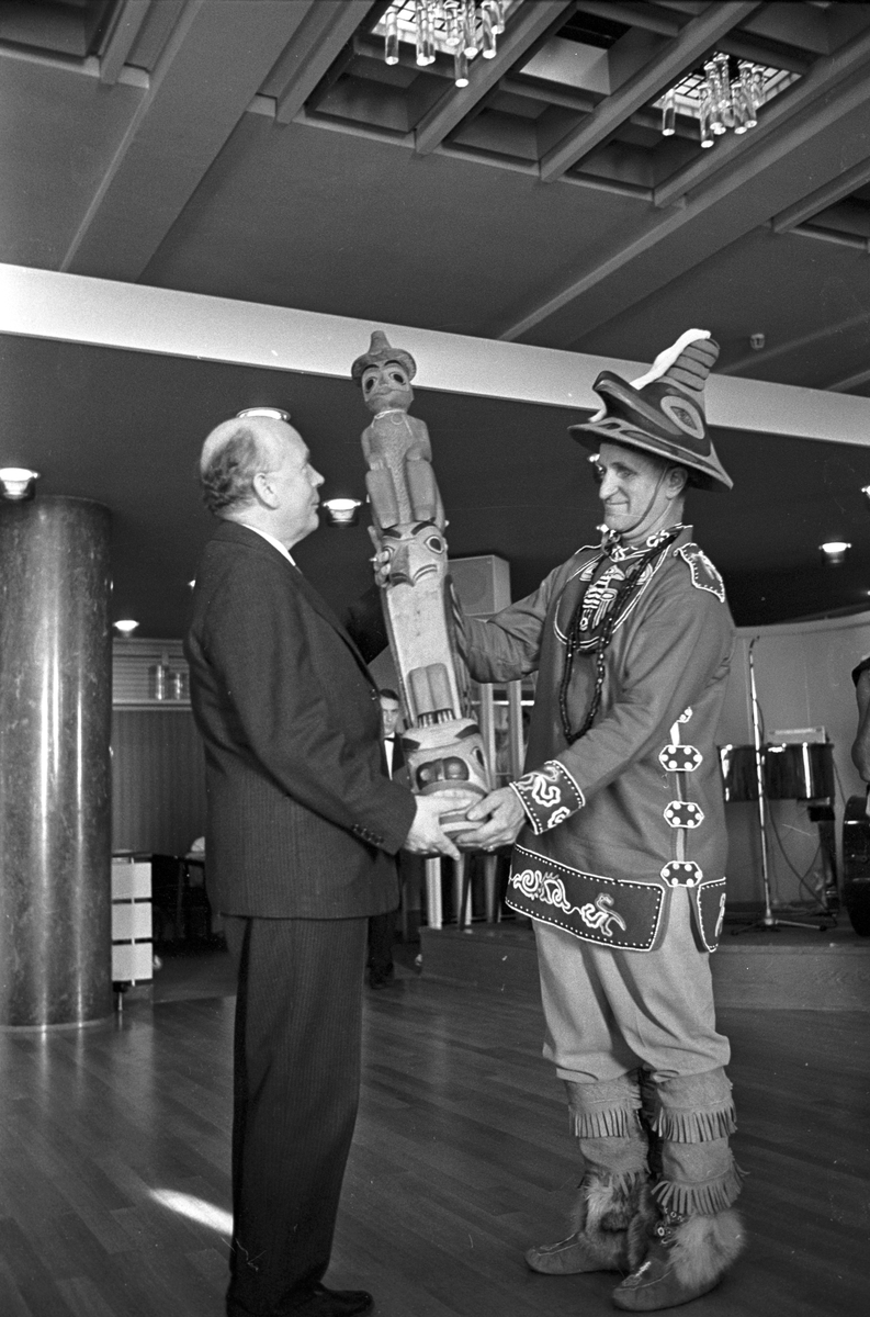 Serie. Indianske dansere fra Alaska opptrer på Fornebu i Oslo. Ordfører Brynjulf Bull får overrakt en indiansk skulptur. Fotografert oktober 1965.