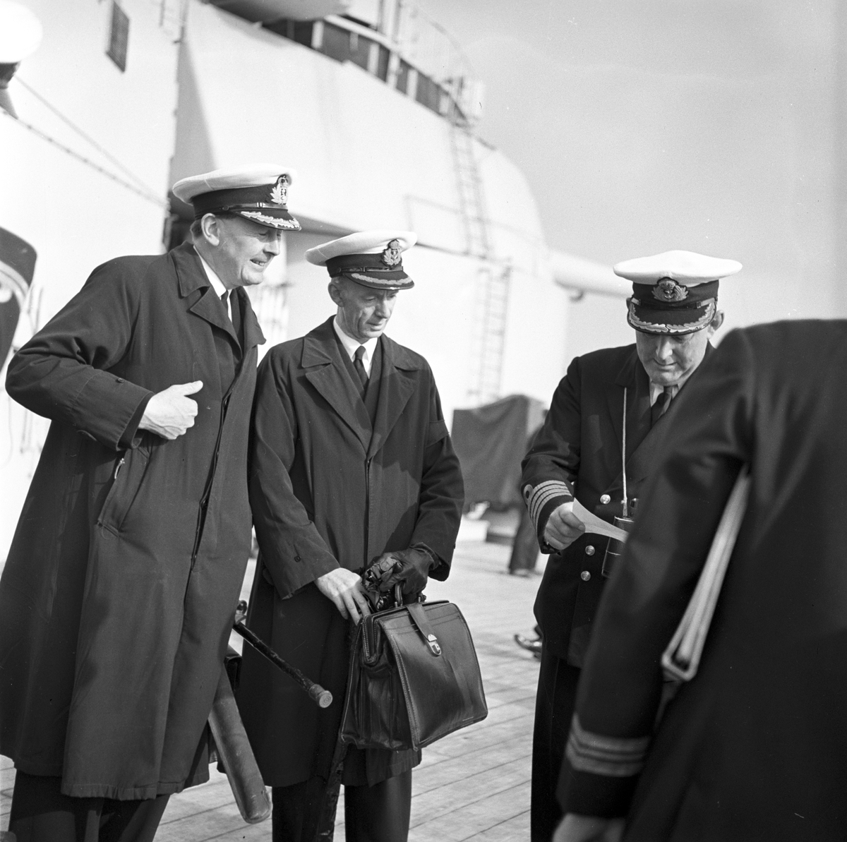 Serie. Det engelske slagskipet HMS Vanguard på flåtebesøk i Oslo. Parade med musikkorps ombord. Noen av mannskapet står med kikkerter og en pusser kanoner. Fotografert 21. juni 1954.