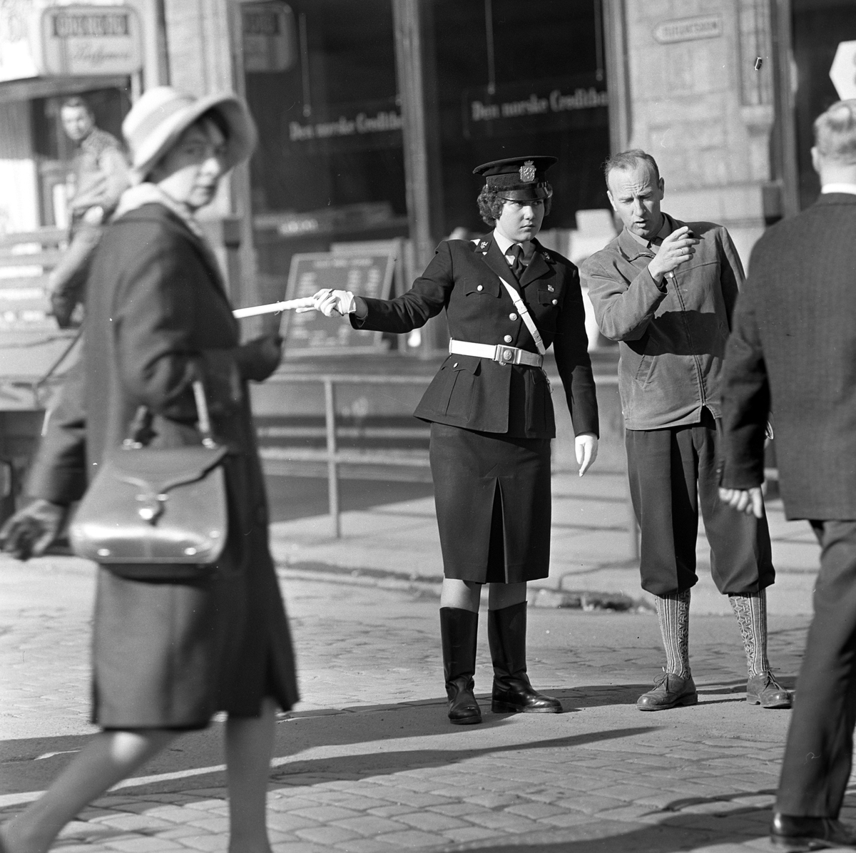 Serie. Kvinnelig trafikkpoliti. Én av dem dirigerer trafikken i krysset  Akersgata/Teatergata. Fotografert april 1962.

