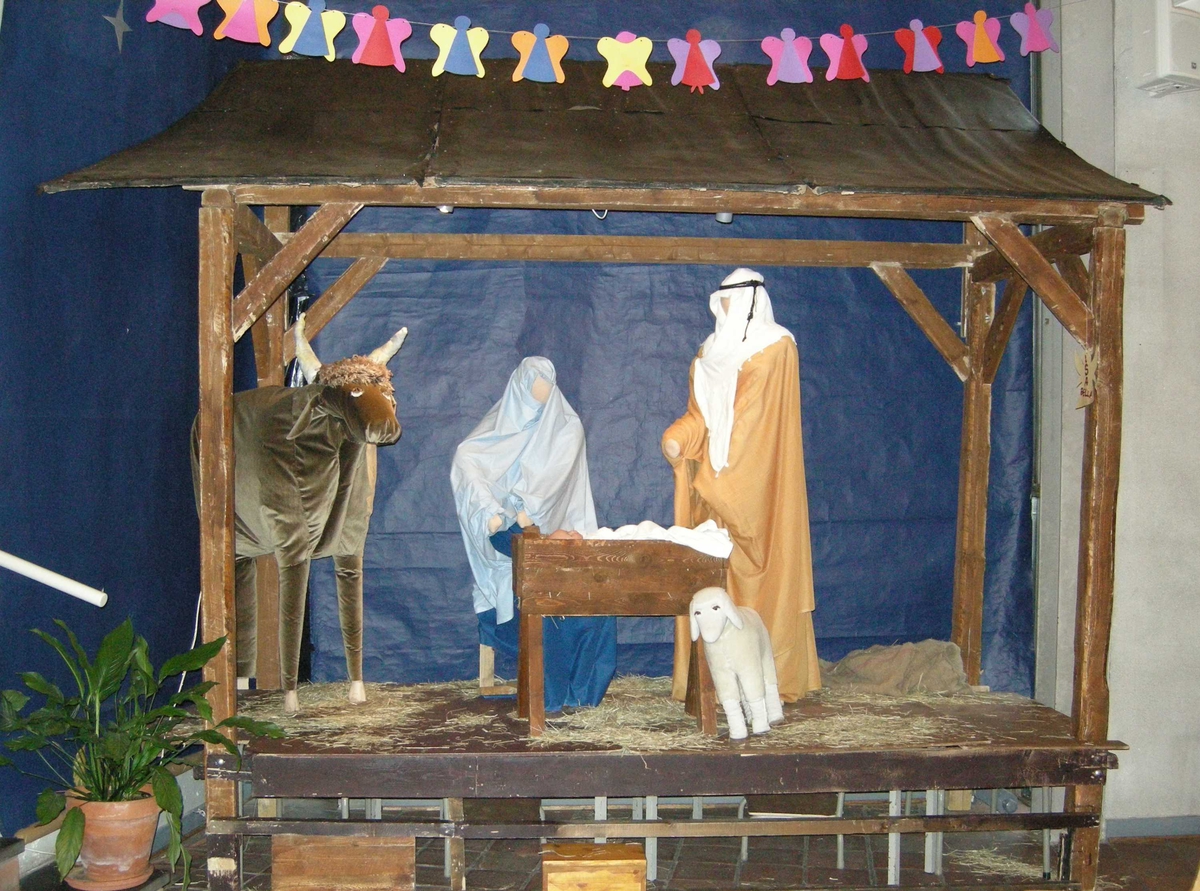 1. juledag i Tonsen kirke, Oslo. 25.12.2007. Julekrybbe i kirken. Girlander med papirengler laget av barn henger over krybben.