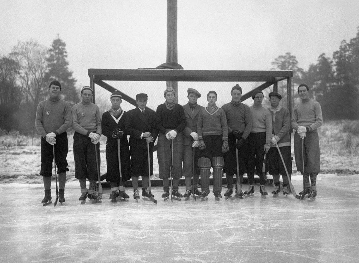 Et bandylag står foran et mål på isen, det først bandylag i B.J.. Fotografert 1933.