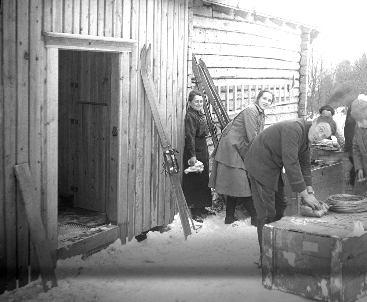 Transport kasser åpnes av julegjester uten for Fagerstua. Fotografert julen 1920.