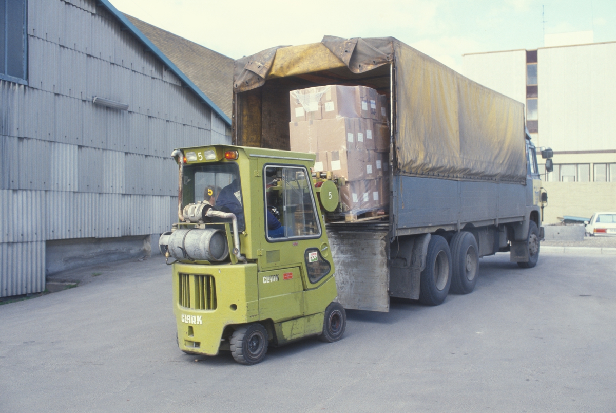 Truck laster esker opp i lastebil. Lager og transport hos Tiedemanns Tobaksfabrik.