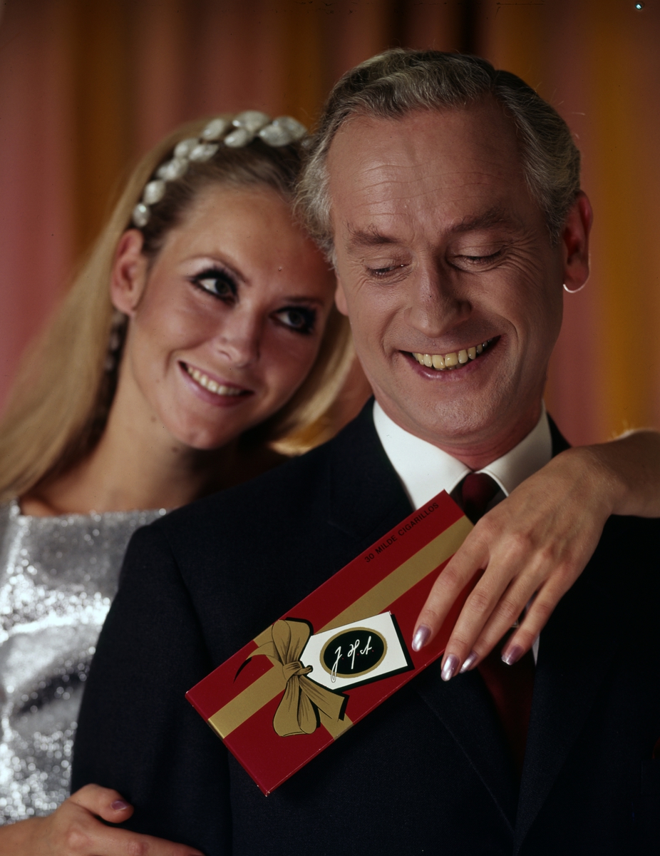 Reklamefoto. Portett av par med en pakke cigarillos fra Johs. N. With.