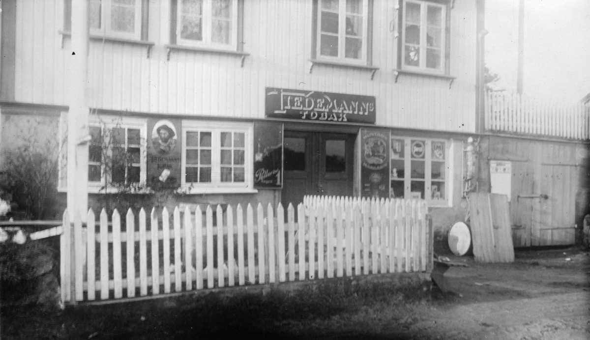 Forretning med reklameskilt fra Tiedemann på veggen i Arendal, 1934.