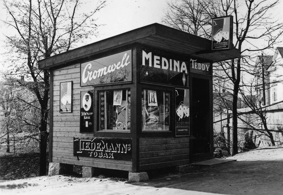 Kiosk eid av Ivar Iversen med reklameskilter fra Tiedemann i Trara i Fredrikstad 1935.