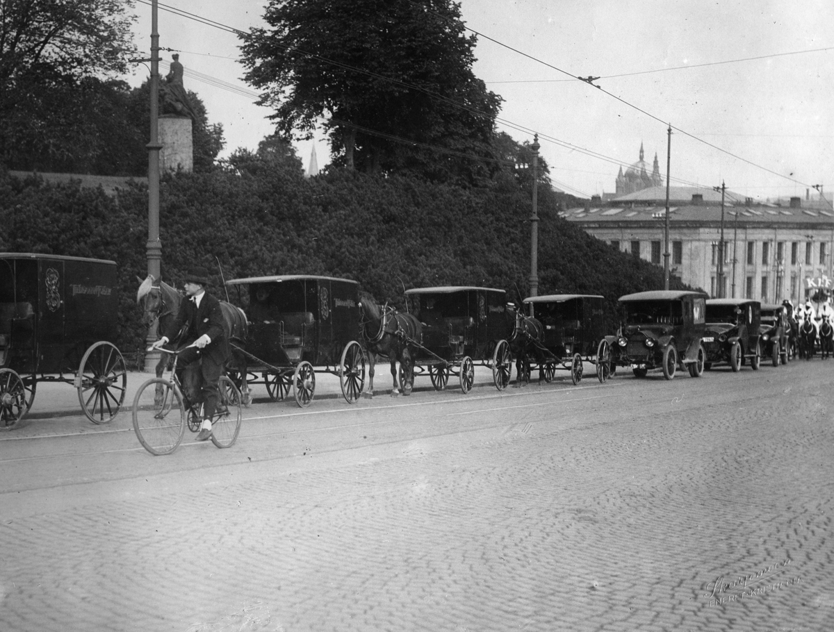 Biler, hester og vogner i et reklameopptog høsten 1926 med flere utkledde menn. Reklame for Kef og Sultan sigaretter.
