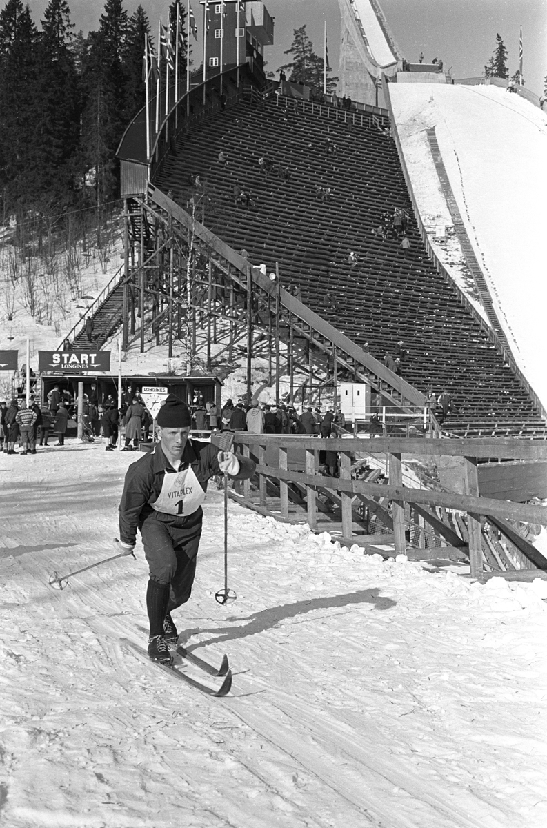 Skiløper med startnummer 1 i Holmenkollen. Holmenkollbakken i bakgrunnen. Holmenkollrennene 1963.