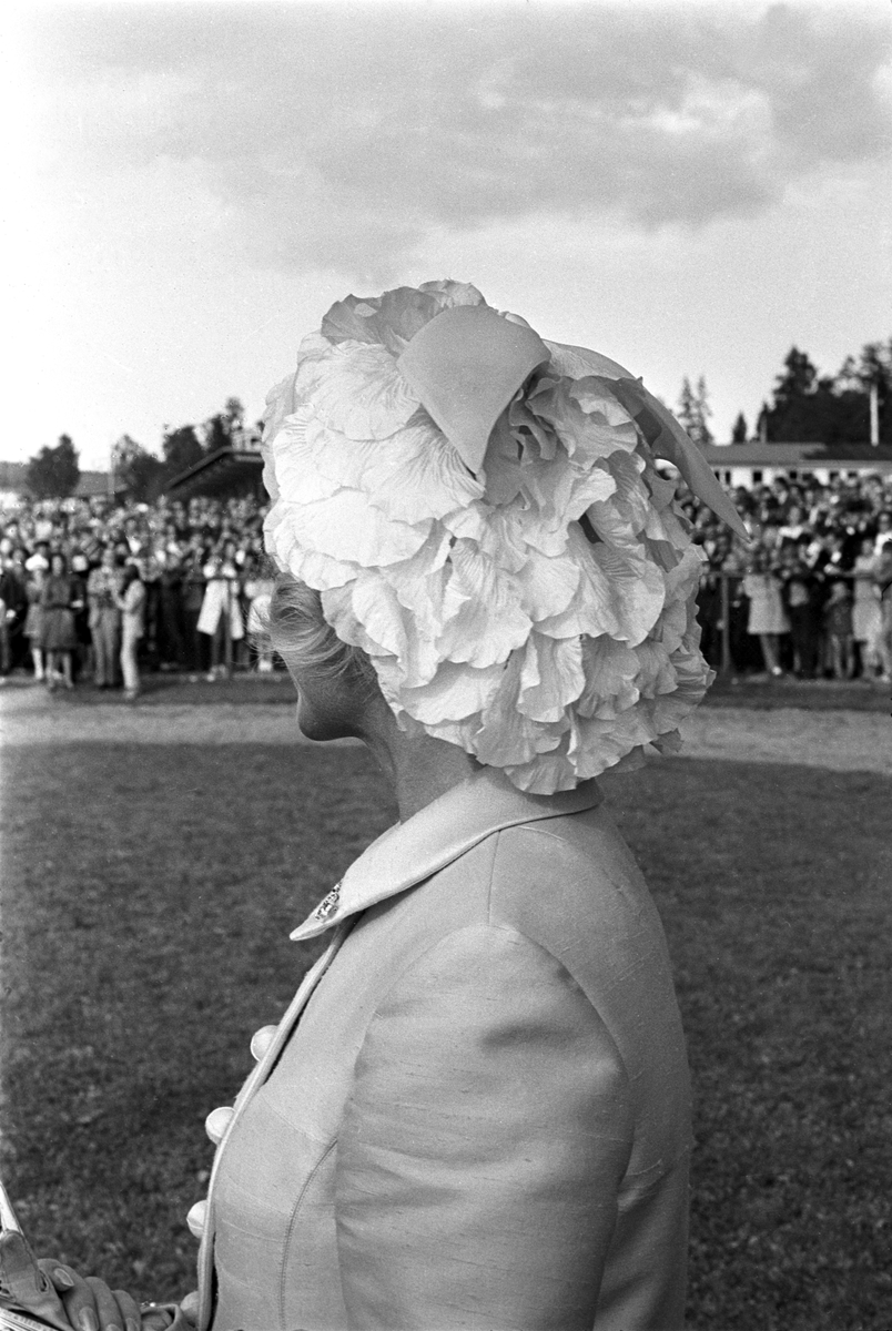 En av deltakerne i damenes hatteparade under Norsk Derby på Øvrevoll galoppbane i Bærum 20. august 1967. Publikum i bakgrunenn.