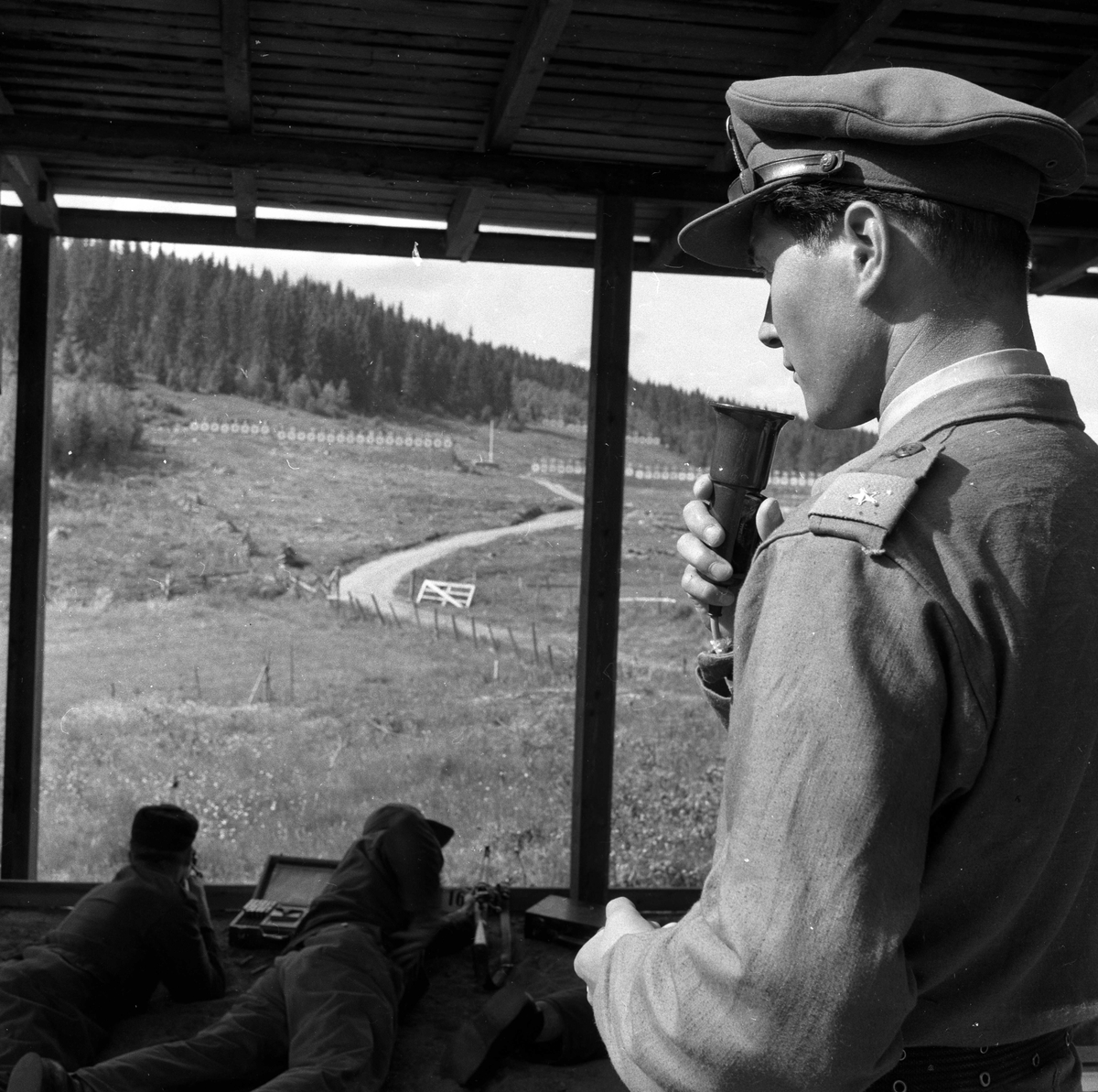 Kongsvinger, 03.- 04.07.1955, landsskytterstevnet. Funksjonær med mikrofon har oversikt over området.