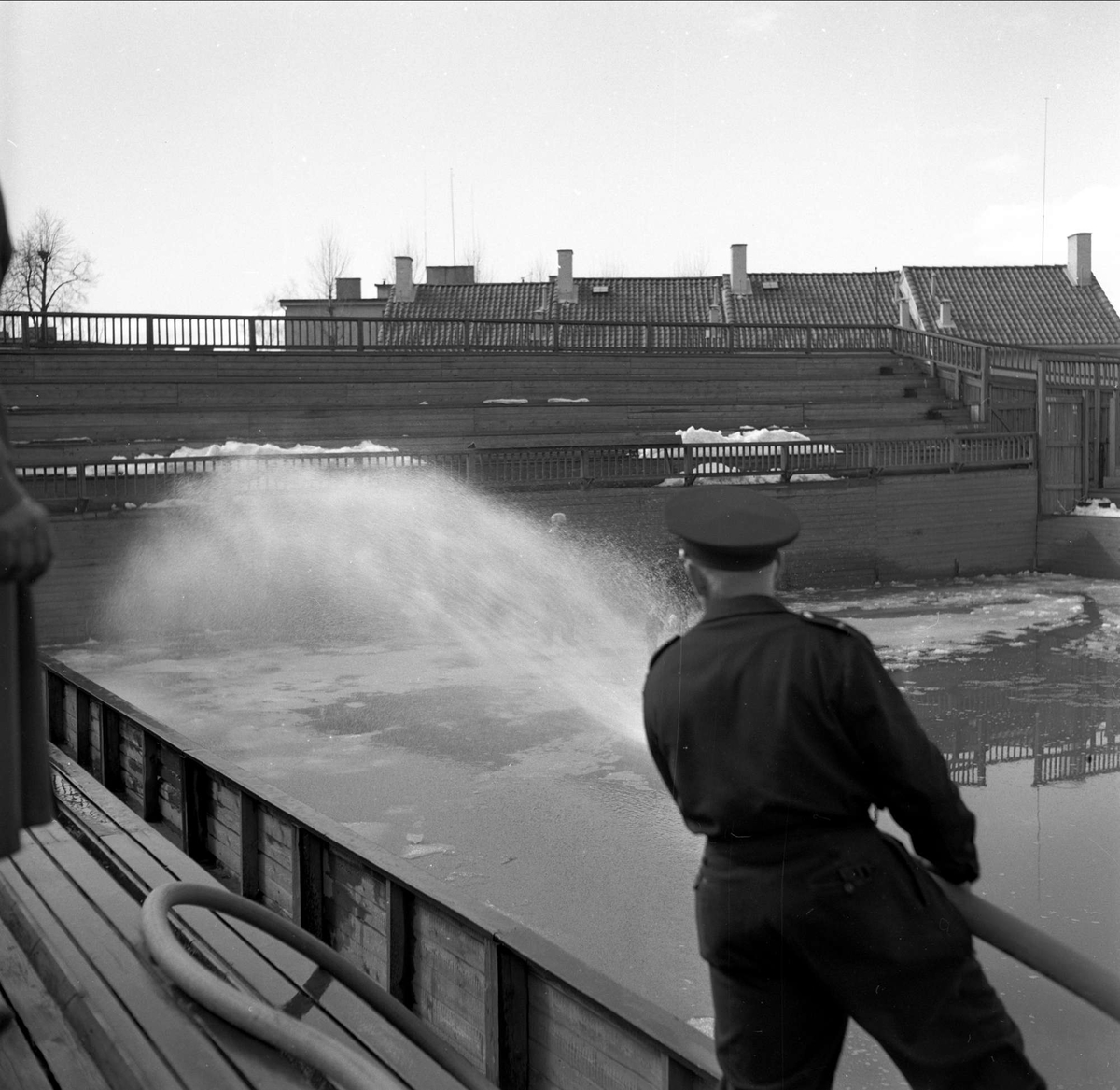 Madserud, Oslo. Menn som spyler idrettsarena med vannslange. 1956.



