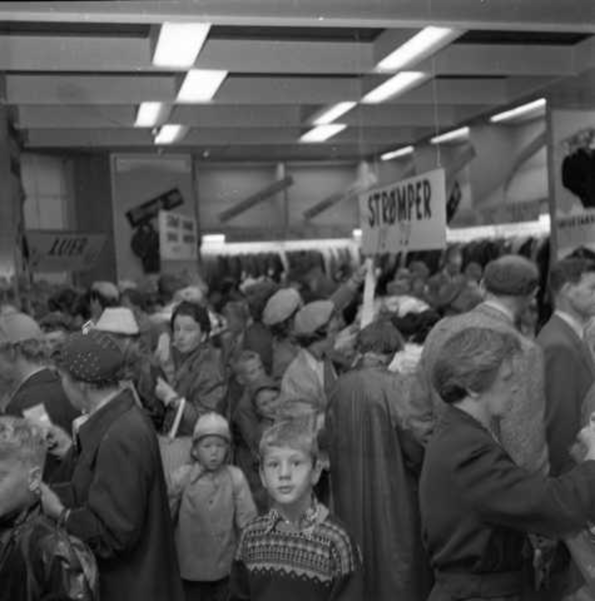 Utsalg av klær, ant. Oslo, 1956. Fra folkemengde i butikkinteriør.