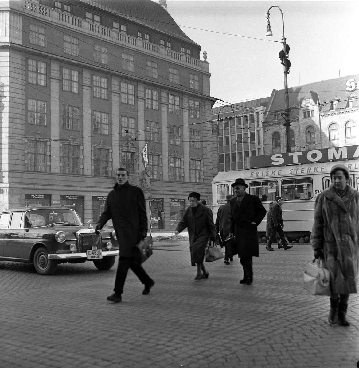 Trafikkpoliti dirigerer trafikken på Jernbanetorget, Oslo, februar 1963.