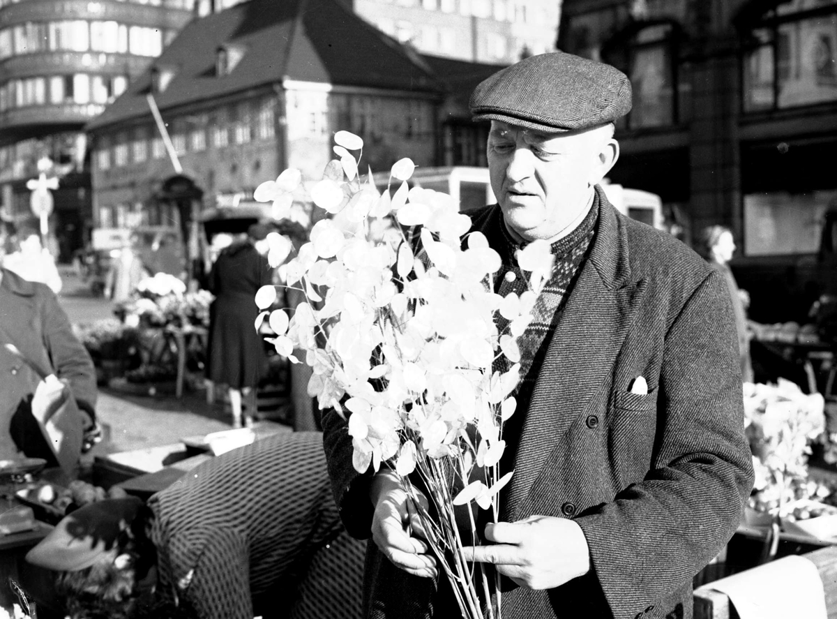 Torgbilder. Stortorvet, Oslo. Mann med blomsterbukett.