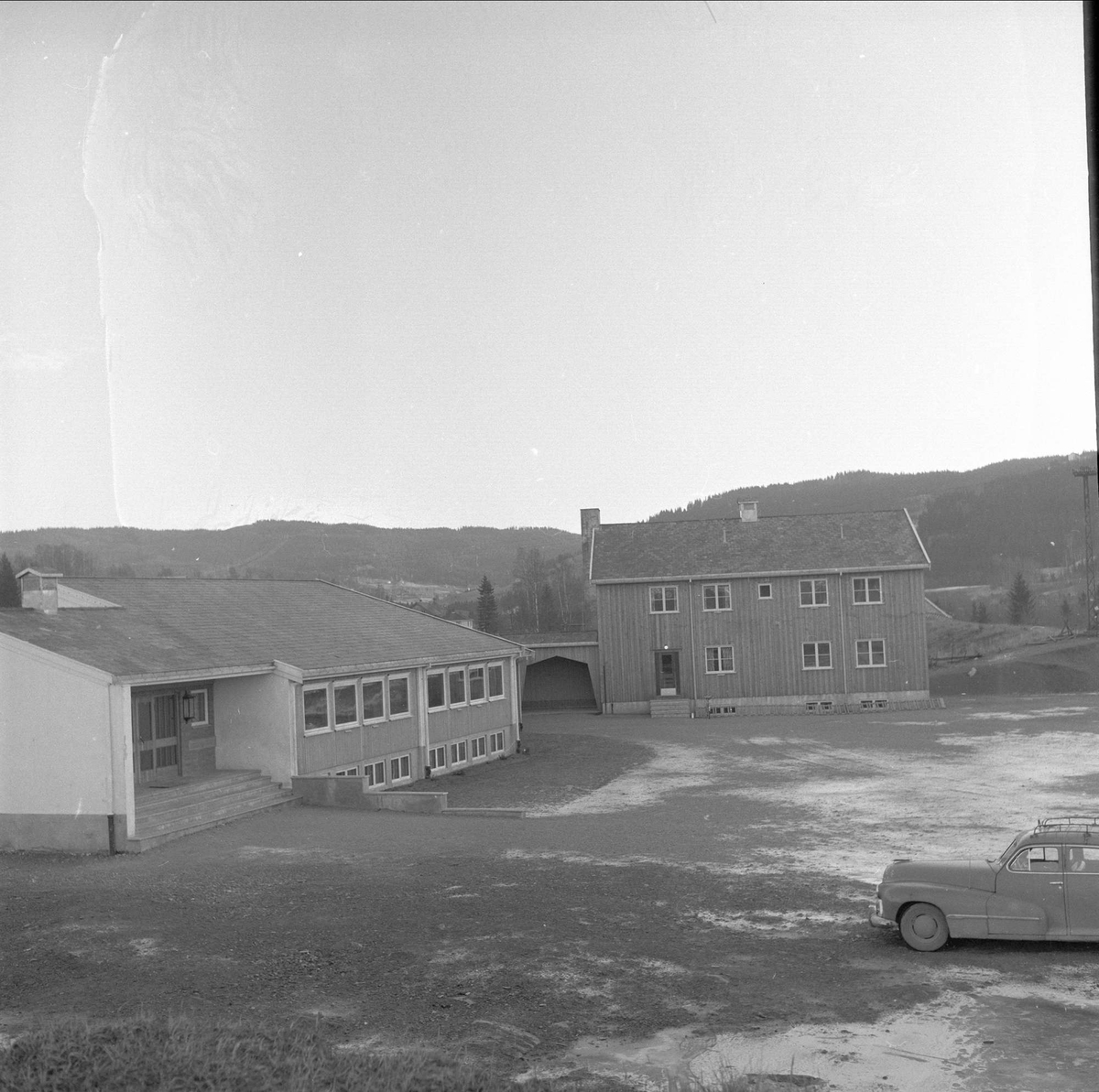 Framhaldsskolen på Frøystad på Roa i Lunner kommune, Oppland, desember 1957. Bygninger og bil.