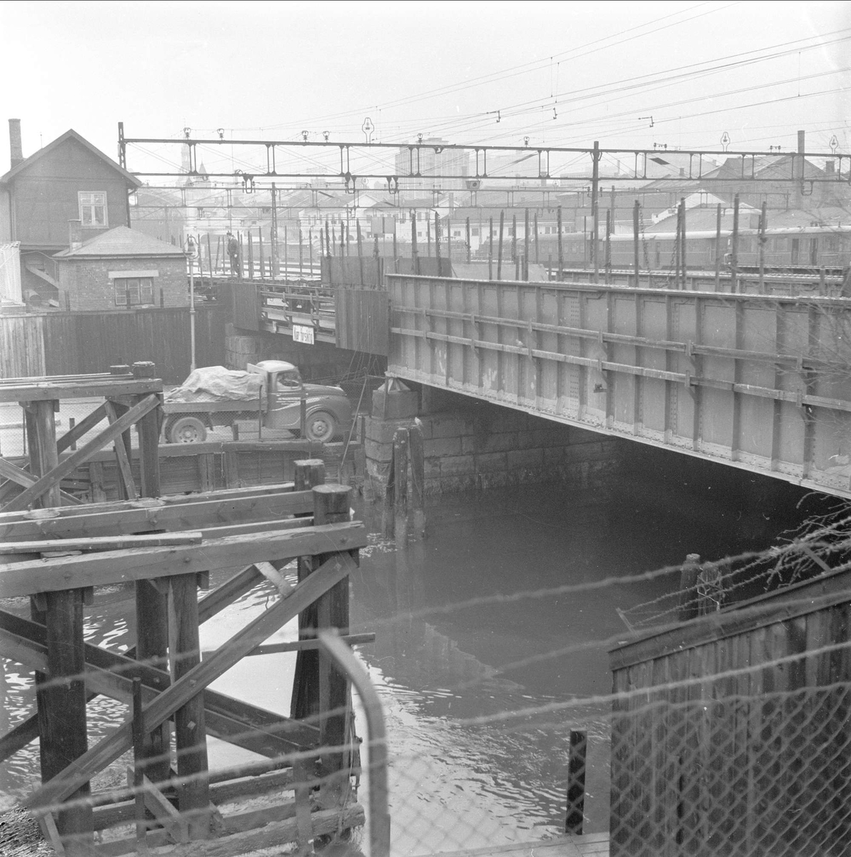 Schweigaards gate, Oslo. 13.11.1959. Bygninger, gjerder, lastebil av typen Austin på vei under jernbanebrua.