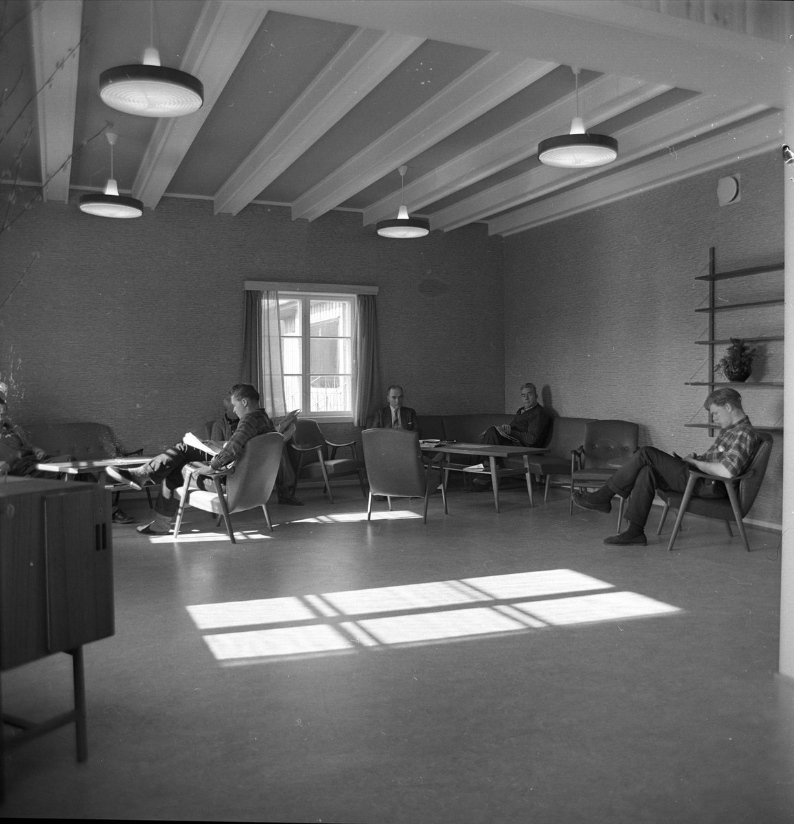 Statens sykehus for epilepsi, Bærum, 12.03.1964. Interiør med bord, stoler og lamper, fra oppholdsrommene, seks menn sitter i stolene.