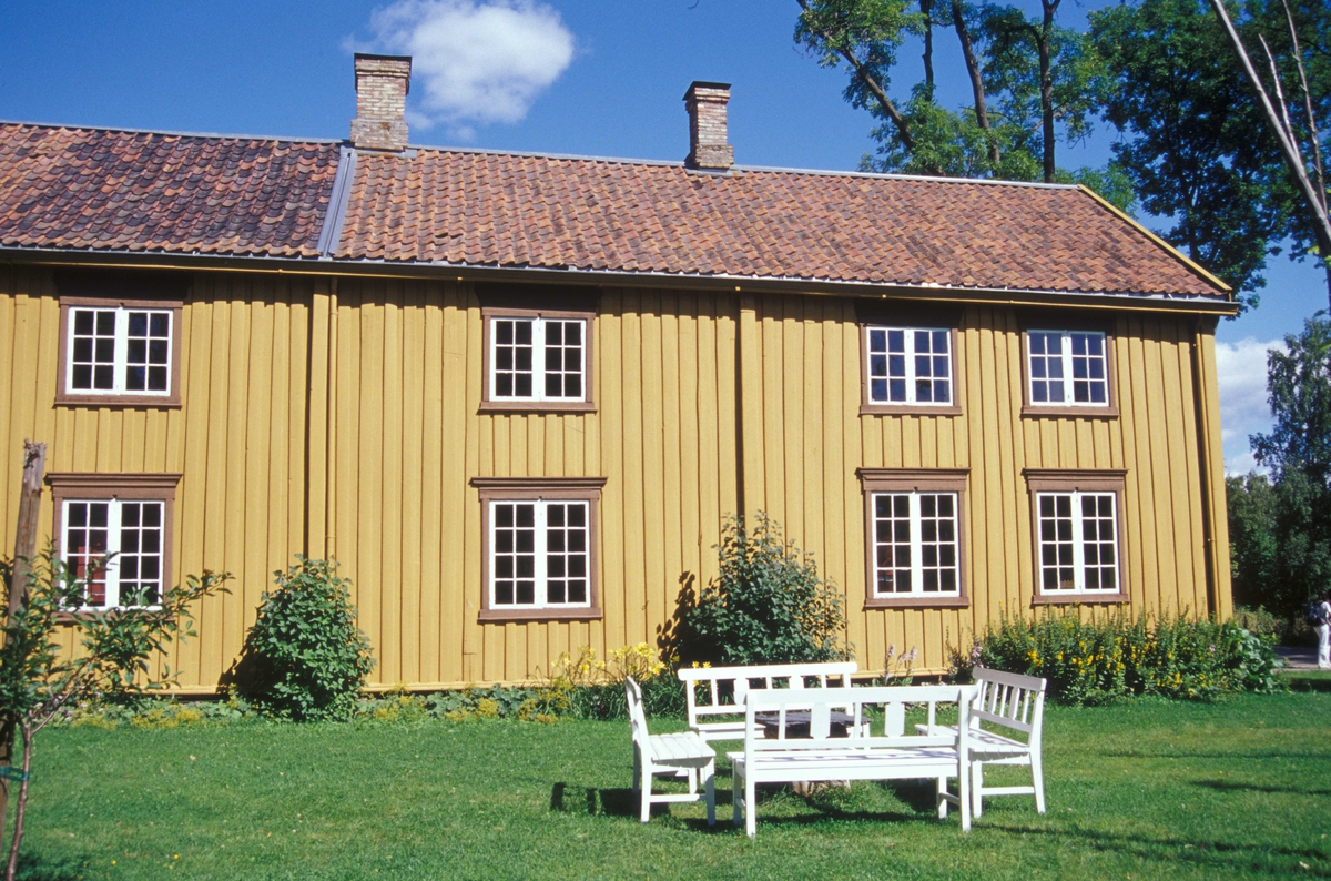 HOVEDBYGNING FRA STIKLESTAD VESTRE I VERDAL, CA. 1800 
Overført til museet 1919, gjenoppført 1926, ominnredet 2010 

Bygningen er et eksempel på de lange våningshusene i Trøndelag, kalt lån. Låna fra Stiklestad Vestre var en del av et firkanttun med bur, løe, vognskjul, stall, fjøs, smie, tørkehus og ”borgestuebygning” (bolighus for tjenestefolk). I 1860-årene ble låna utvidet i lengden med et tilbygg på ca. 10 meter, som inneholdt kjøkken, masstu (bryggerhus), forgang og kjøkkeninngang med egen inngangsdør. Dette tilbygget ble ikke tatt med da låna ble flyttet til museet. Gården var i bondeeie da låna ble bygd, men ble senere solgt, og var det meste av 1800-tallet eid av offisersfamilier. I 1894 kjøpte Staten gården til prestegård, og låna ble prestebolig, som den var fram til den ble flyttet til museet. Museet tilbakeførte da bygningen i tid til ca. 1800, og innredet den som et bolighus fra en trøndergård på den tiden. I 2010 ble låna ominnredet for å vise et eksempel på 1950-tallets boskikk, slik en barnefamilie i Trønde¬ag kunne ha bodd da. 

(Tekst hentet fra By og bygd 43,2010)
