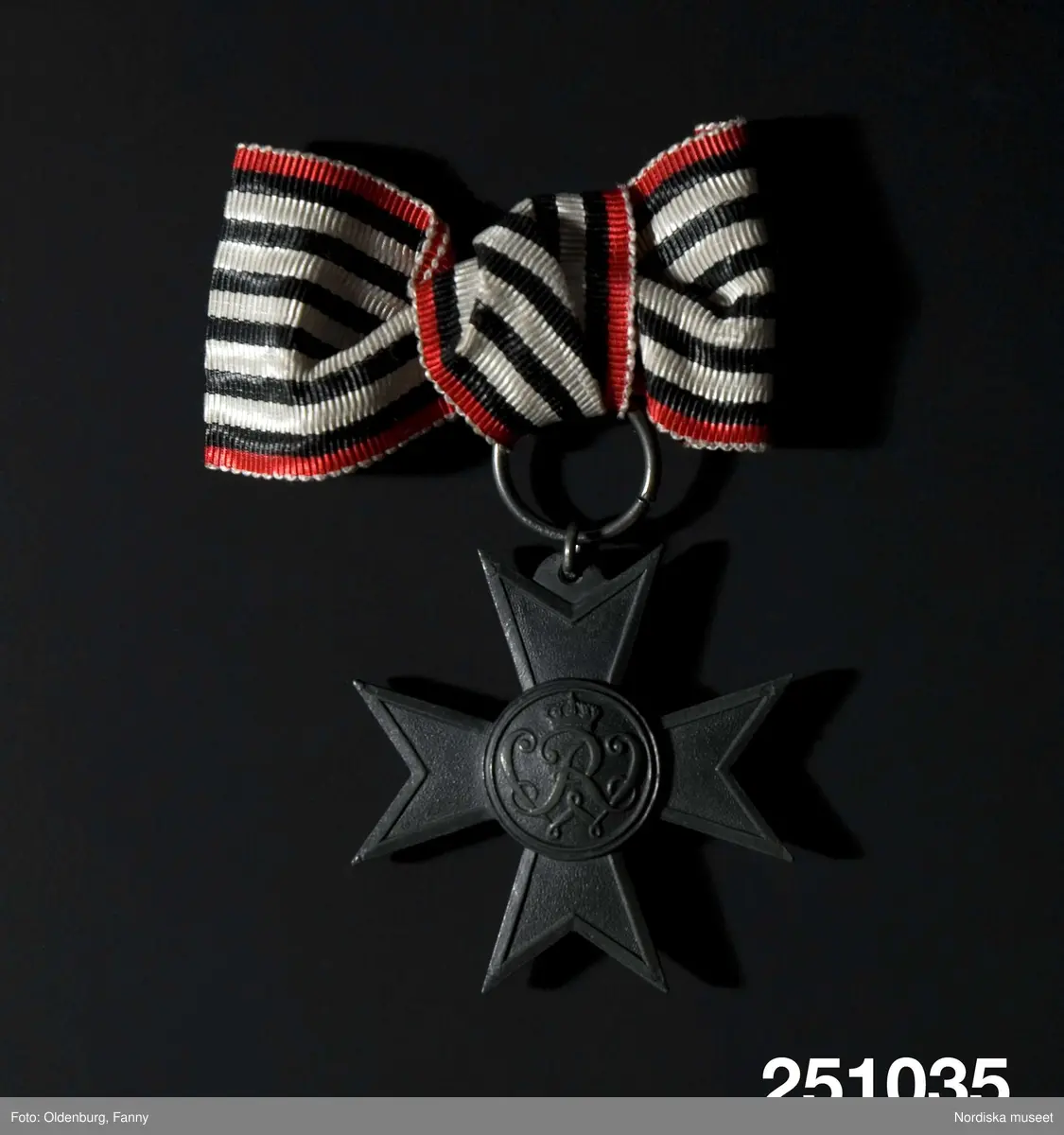 Huvudliggaren:
"Belöningstecken, stjärna av grå metall med mittrundel, på vars sidor står krönt 'R W' resp. 'Für Kriegshilfsdienst; i svart-vit-röd bandrosett med säkerhetsnål.
G 30/8 1955 Fröken Ellen von Platens dödsbo, Stockholm."