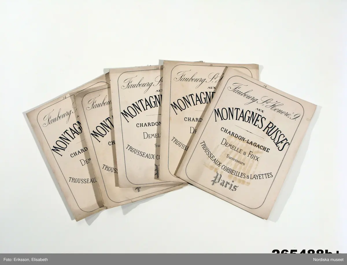 En samling tygprover   för finare klänningsmodeller inklistrade i 92  foldrar, litt a-f. Skickade av firman Montagnes Russes i Paris i mitten av 1870-talet  till den svenska drottningen Josefin, 1807-1877. 
Benämningar på olika kvaliteter: Drap ´Orient, Gaze de Nimes, diagonale laine, Drap Cachemire, Cre`pe lisse, Serge Anglaise, Tulle Malines, Tulle Bruxelles, Haitienne, Armure laine, Bazin, Tulle Illusion, Vigogne Cagchemire, Popeline laine, Grain de poudre, Gros d´Alma, Tulle parisienne, Chalys, Mohair glacé, Brandenbourg laine, Percale imprimé, Batiste.
/Berit Eldvik 2011-02-01