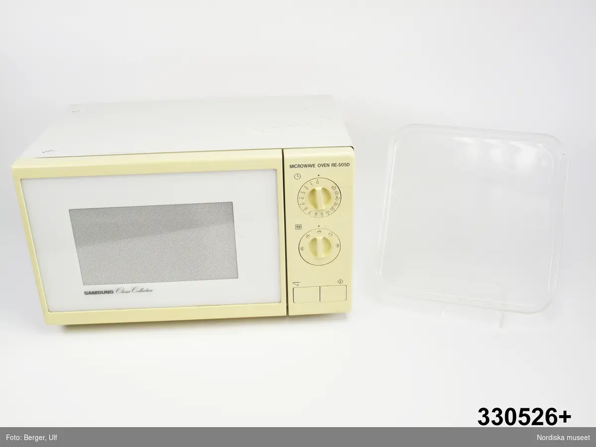 Mikrovågsugn, rektangulär liggande form. hölje i vit plåt och vit plast. Dörr och vred på framsidan samt text "MICROWAVE OVEN RE-505D" ovanför vreden, samt "SAMSUNG Classic Collection" på dörren. På baksidan varningstexter på de nordiska språken. På svenska "VARNING ! UGNEN FÖR [sic] EJ KÖRAS TOM. SÄTT INTE IN MAT SOM ÄR INSLAGEN I METALLFOLIE ELLER ULAGS PÅ FAT AV METALL. / VARNING ! MIKROVÅGSENERGI! AVLÄCSNA [sic] INTE DENNA TÄCKPLÅT. / VARNING ! FÖRE SERVICE DRAG UT STICKPROPPEN. SERVICE FÅR UTFÖRAS ENDAST AV AUKTORISERAD TEKNIKER.". Även teknisk information, bl.a. "Input 220-230V 50Hz 1300W". Stående på fyra svarta små plastfötter. 
Inuti lös rektangulär glasbricka märkt undertill "FOR MICROWAVE OVEN ONLY".
Ugnsluckan öppnas genom att man trycker in den vänstra knappen på framsidan. Den högra knappen startar ugnen. 
Anm. Ovanpå avtryck från tidningar samt prislappar "Kr 120". OBS viktigt att prislappar och avtrycken från tidningar bevaras, se under "Historik". 
Plasten i dörren har troligen gulnat något. Ugnen har haft grå sladd med kontakt på baksidan. 
/Leif Wallin 2011-01-13