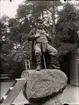 Jödde i Göljaryd (Karl Petter Rosén 1855-1900) poserar på Jödde-stenen på Skansen. Bredvid honom står ett dragspel.