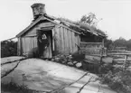 Backstuga vid Linnabacken, Bälstorp, Torsås socken, Småland. Kvinnan på bilden var 82 år och hade bott i stugan sedan hon vid 22 års ålder gifte sig.