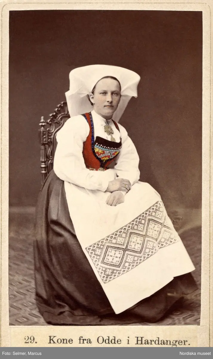 "Kone fra Odde i Hardanger." Ett färglagt foto på en kvinna i sockendräkt från Hardanger, Norge.