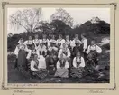 Gruppbild av personalen på Skansen, kullor och en man i mitten. Gåva till Arthur Hazelius. 