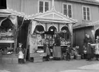 Barn och kvinnor framför Charlotta Forsbergs karamellstånd i Strömstad, 1890-tal