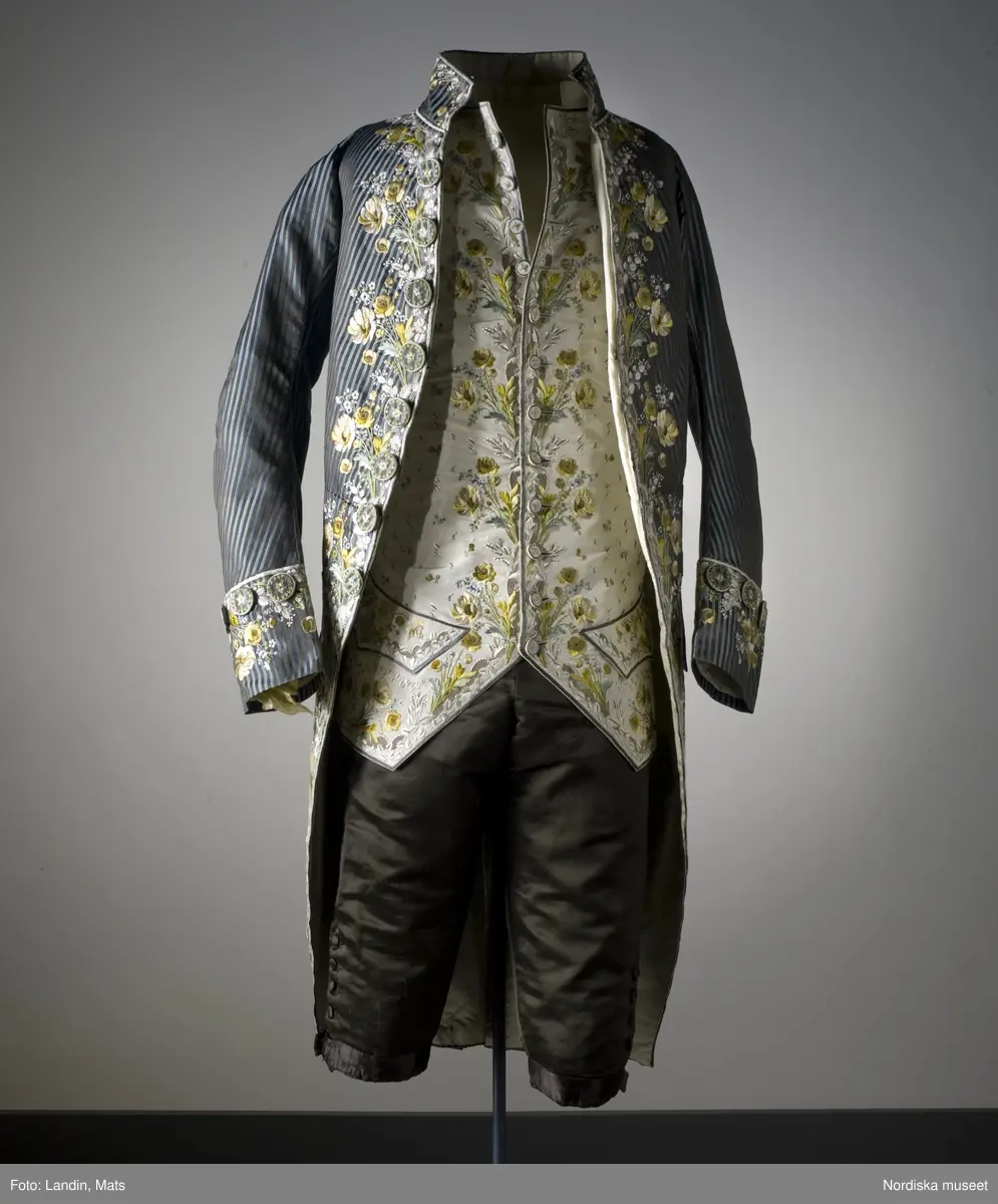 Mansdräkt med rock och väst i broderat siden. Tillverkad i Frankrike omkring 1785. Har burits av Axel von Fersen d.y. Nordiska museet inv nr 154745.