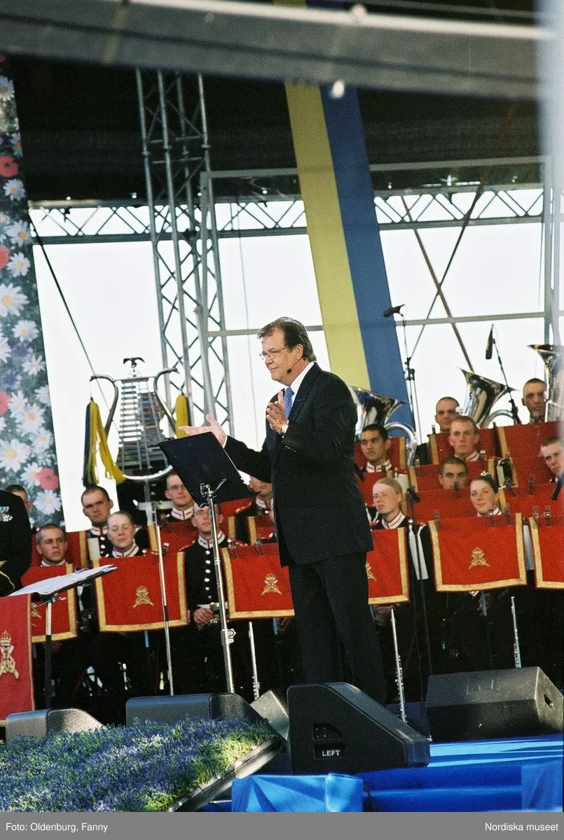 Firandet av den svenska nationaldagen den 6 juni 2004 på Skansen, Stockholm. Den kungliga familjen. Orkester. Publik. Artisterna Shirley Clamp, Tomas Ledin och Lasse Berghagen. Programledaren Agneta Bolme Börjefors.