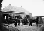 Trelleborgs brandkår. Från 1896 fanns i Trelleborg en kombinerad polis och brandkår vid Nygatan i kvarteret Igelkotten. I bildens mitt står major Malmros. Till vänster om honom polis Ferm och längst till höger polis Björk.