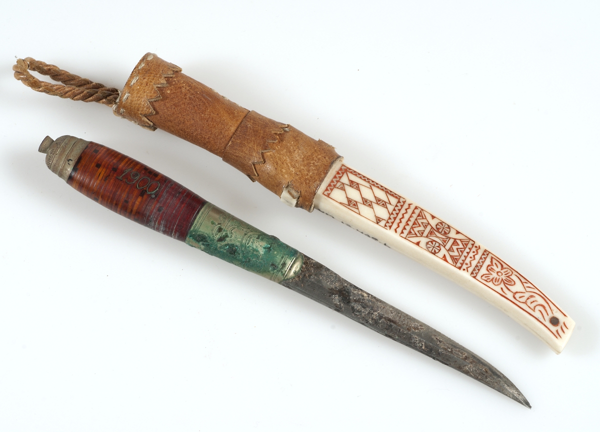 Kniv med slida av horn och skinn.
a) Kniv: skaft av näver med mönster och årtalet 1900 av inlagd vitmetalltråd (trådintarsia). Vitmetallbeslag i skaftets båda ändar. Blad av stål med inristad dekor och text på samiska: kauhavan puukkolehdas, samt ett oläsligt ord.
b) Slida: nederdelen av horn, något svängd. Ena sidan med inristat mönster färgat med rött i fördjupningarna, andra sidan med utskurenbladranka i relief, färgad med svart i fördjupningarna. Överdel av brunt skinn, hopsydd med lintråd, ögla av lädersnodd. Kniven har använts vid korgbindning.