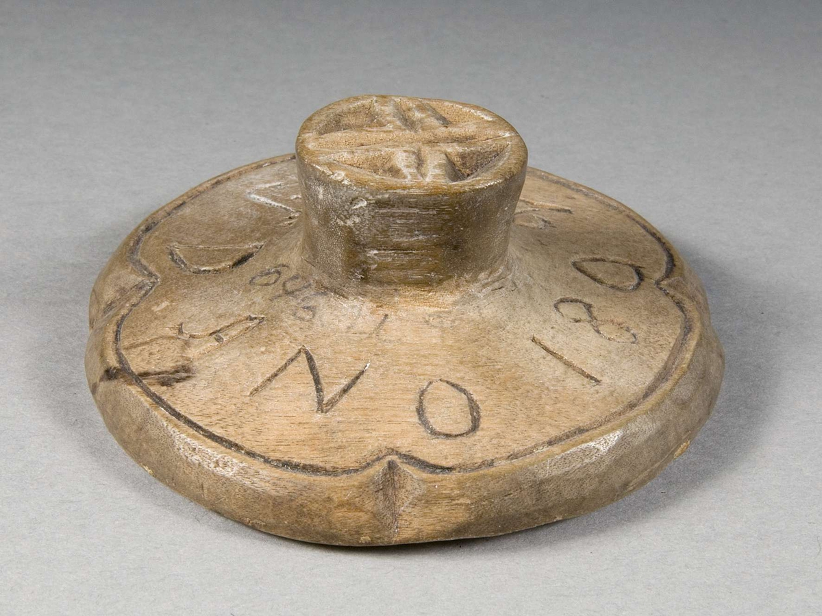 Messmörsstämpel av trä. På ovansidan initialerna BJD och årtal: ano 1802.
