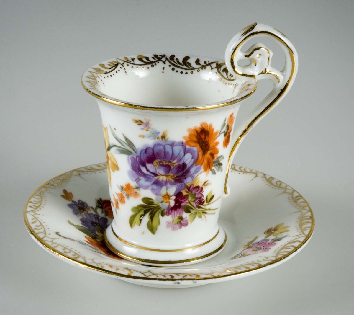 Sex kaffekoppar med fat, av vitt porslin. Guldkantsdekor. Blommålning i olika motiv i rosa, orange, blått, grönt, lila, gult mm. Av märket Meissen.


